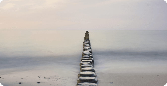 Wooden posts extending into misty water